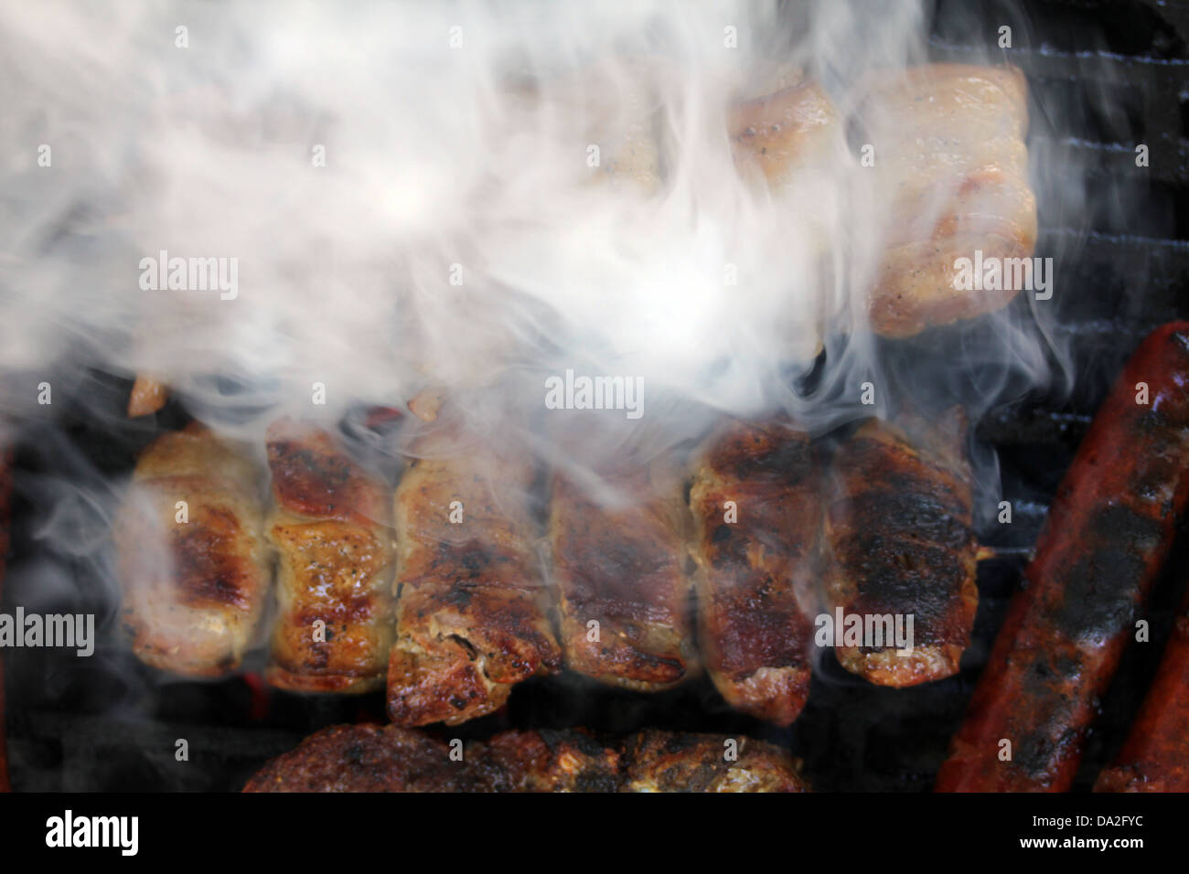 Closeup Aufnahme von Fleisch auf dem Grill mit viel Rauch. Stockfoto