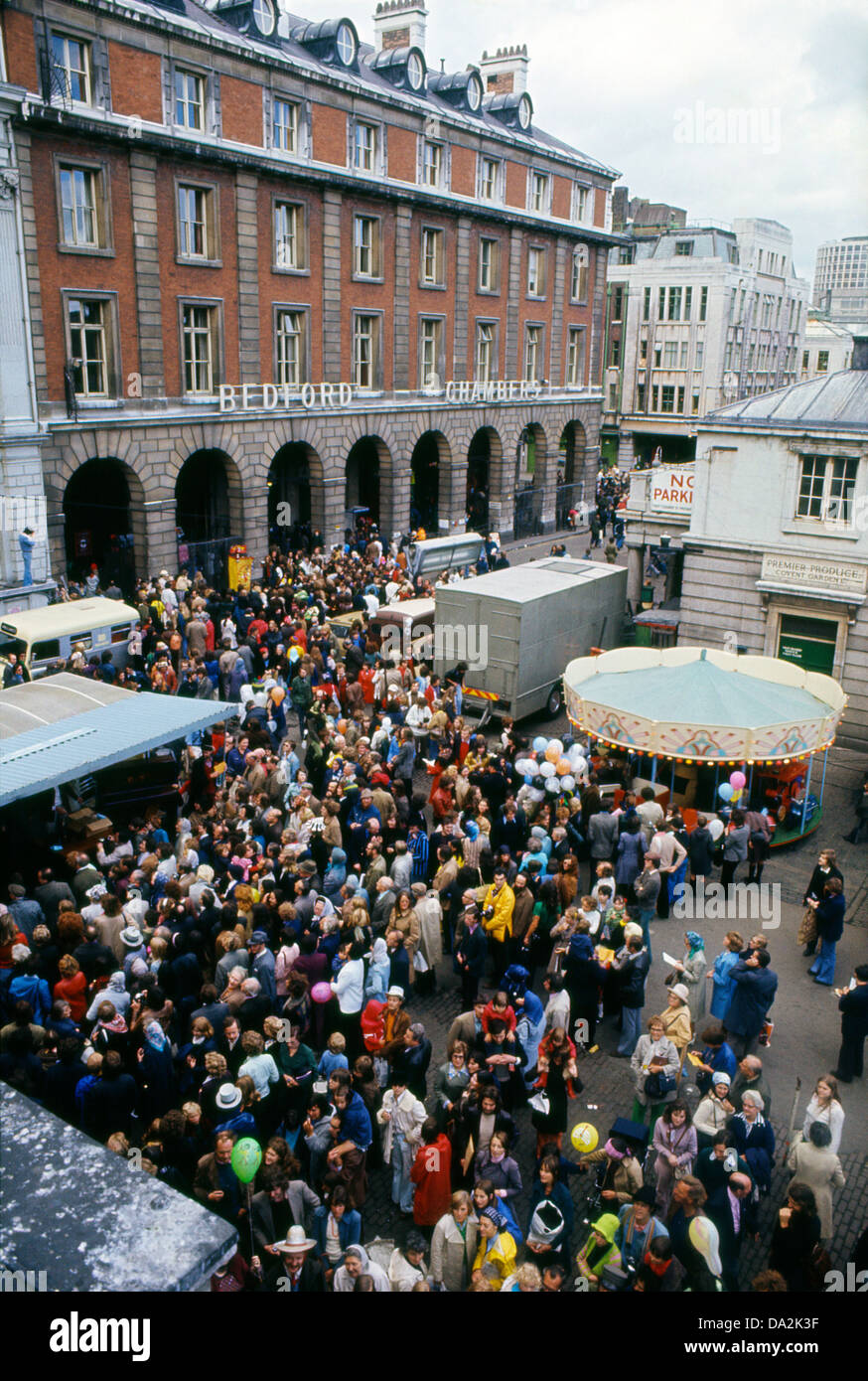 Menschenmenge, die Straßentheater auf dem alten Covent Garden Market und Blick auf die Bedford Chambers beobachten, schildert das Gebäude mit Bögen in London WC2 England Großbritannien 1973 KATHY DEWITT Stockfoto