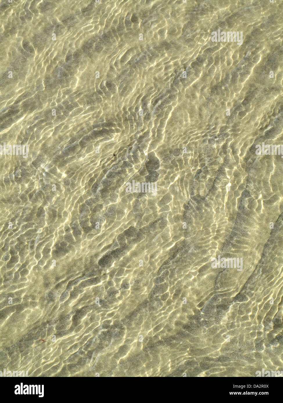 Zufällige, abstrakte Muster, die von der Flut am Sandstrand von Worthing Beach, West Sussex, UK Stockfoto