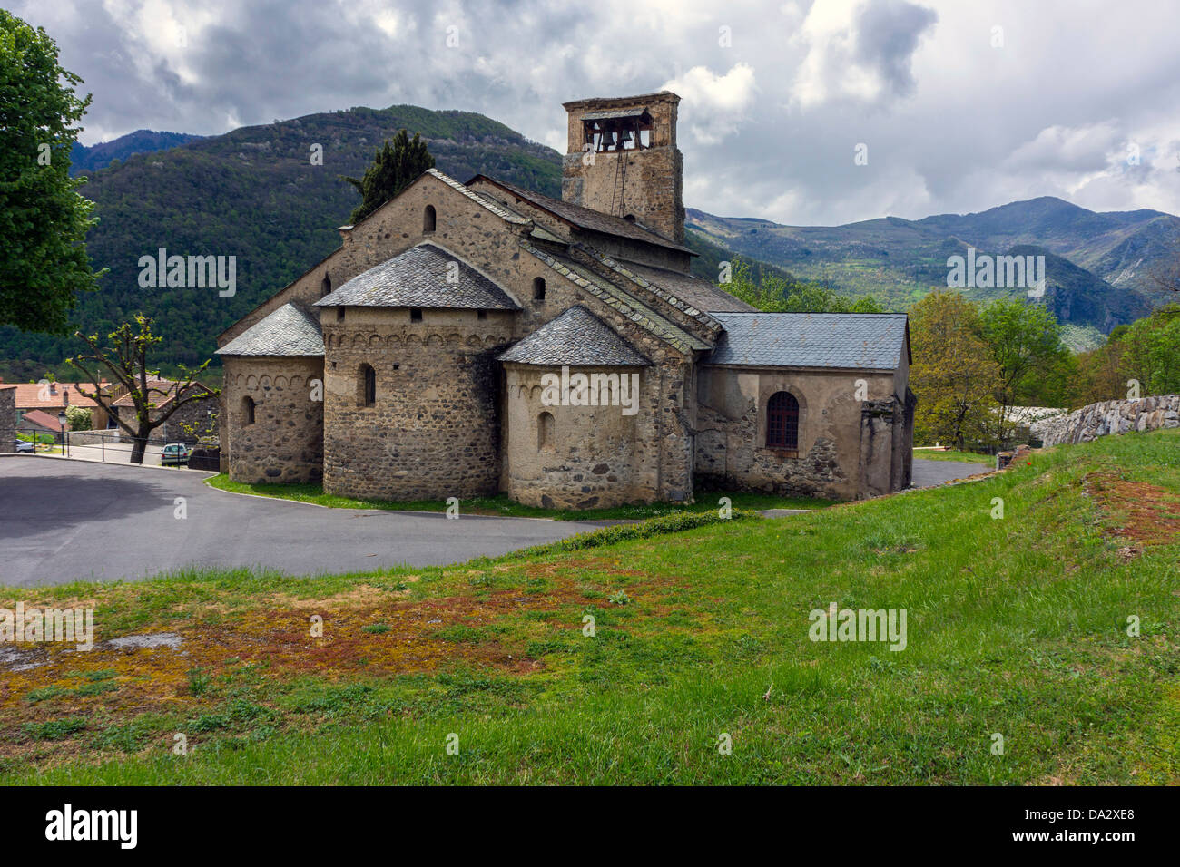 Alte romanische Kirche unter grauem Himmel und Berge Stockfoto