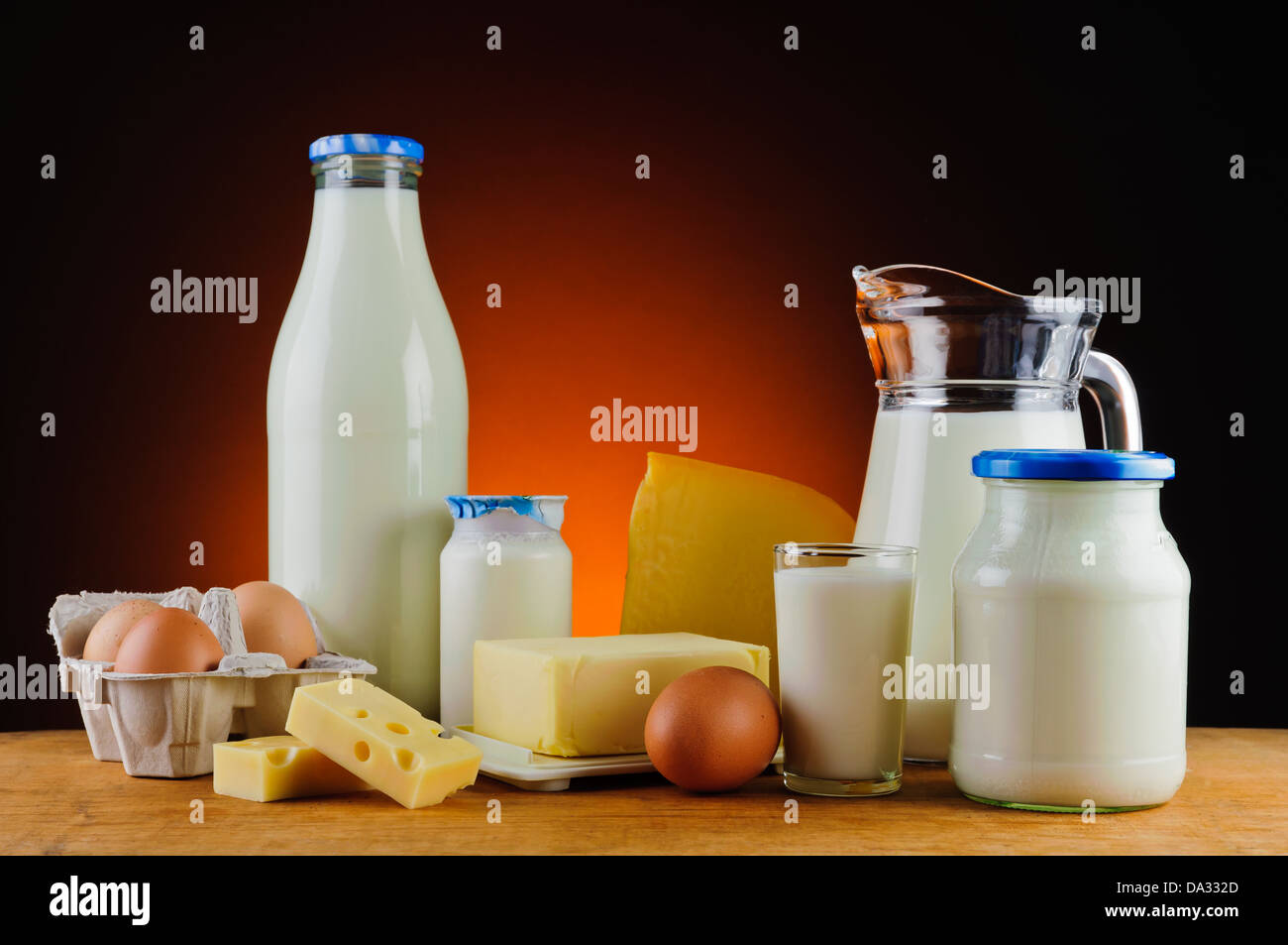 Stillleben mit Milch, Käse, Butter, Eiern und Sahne auf einem Holztisch Stockfoto