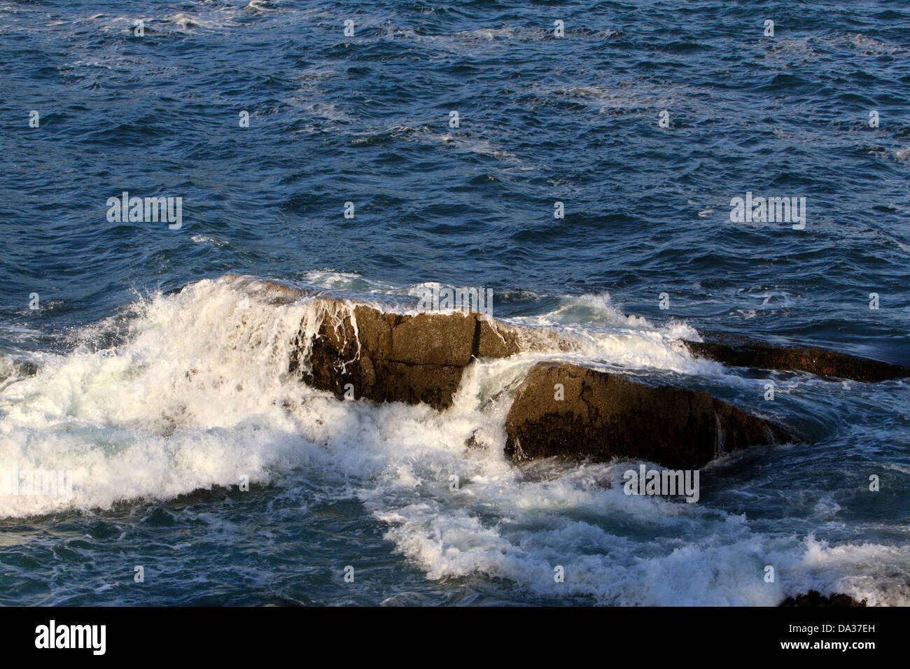 Ozean-Welle rollt über einen Felsen. Stockfoto