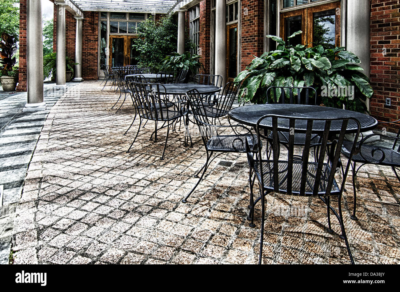 Dieses Bild ist eine steinerne Terrasse mit Schmiedeeisen Tische und Stühle auf dem Alabama Shakespeare Festival in Montgomery, Alabama. Stockfoto