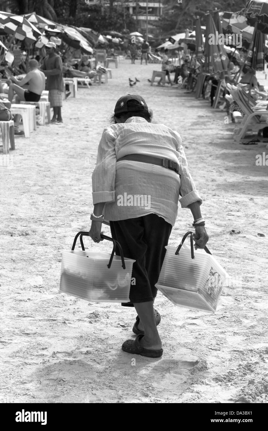 Ältere Thai Beach Hausierer verkauft Getränke und Snacks am Strand. Stockfoto