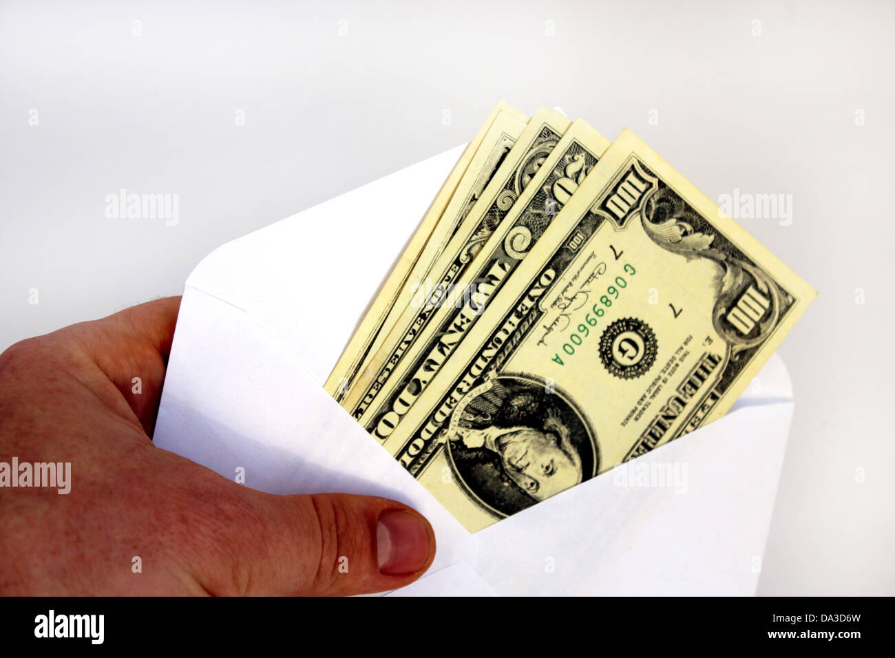 Hand hält-Dollar-Banknoten in Umschlag als Bestechung isoliert auf weißem Hintergrund Stockfoto
