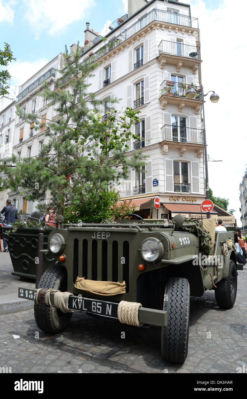 Ein Jeep aus Kriegszeiten, der in einer Straße in Montmartre geparkt hat, in einem zeitlosen Bild. Montmartre ist ein Hügel im Norden von Paris, Frankreich. Die Befreiung des Pariser Konzepts Stockfoto