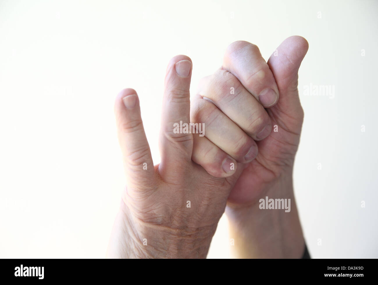 ein Mann greift die ersten beiden Finger der linken hand Stockfoto