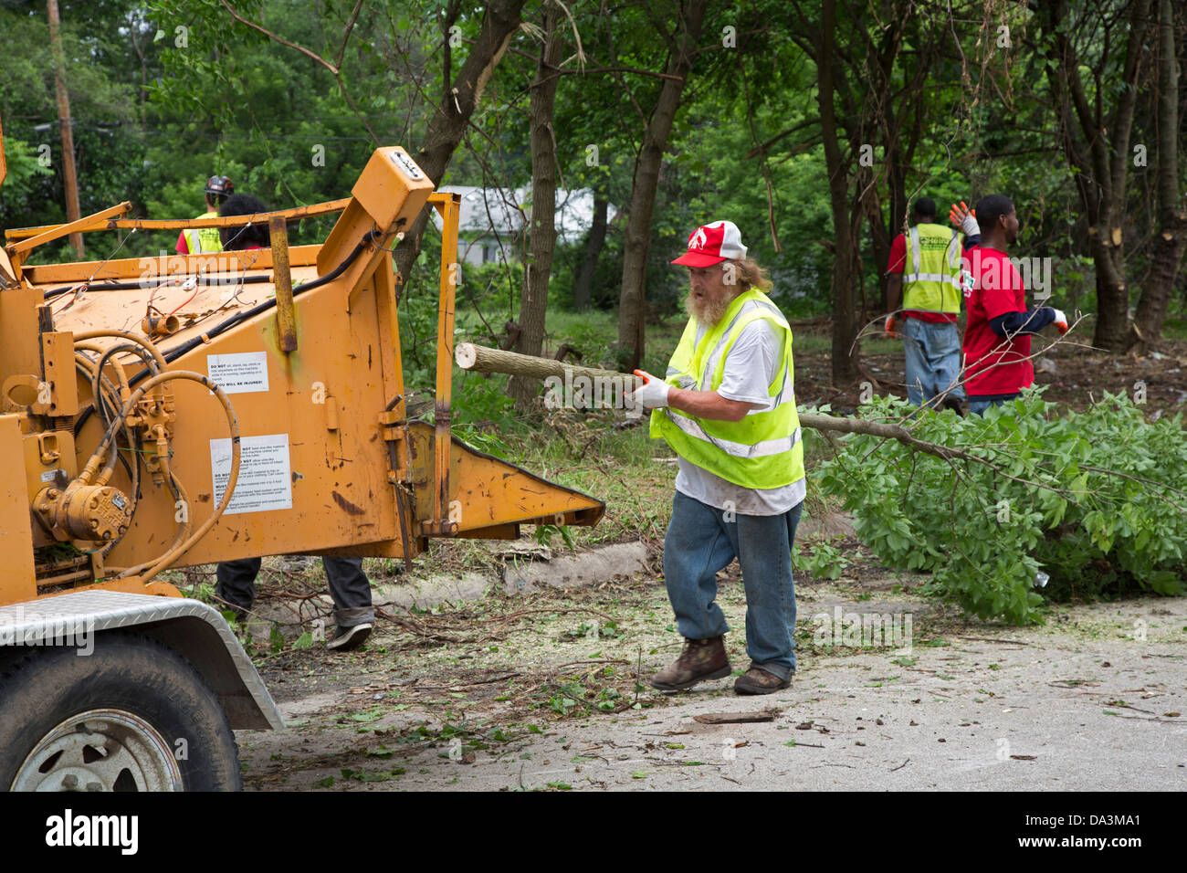 Arbeiter füttern Bush und kleine Bäume in einem Häcksler wie Detroit Blight Autorität der Brightmoor Nachbarschaft bereinigt. Stockfoto