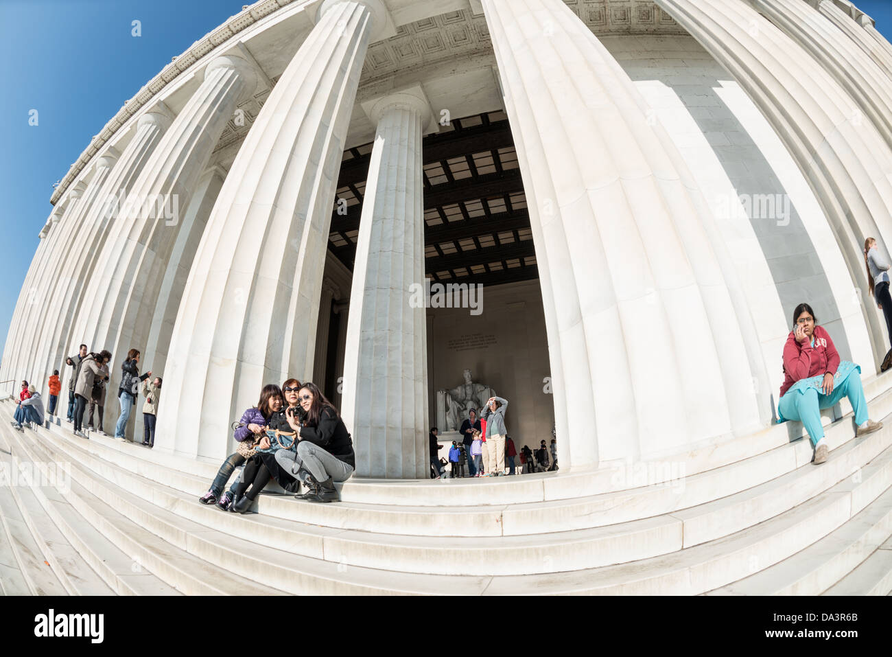 WASHINGTON DC, USA-Touristen sitzen auf den Stufen des Lincoln Memorial in der Sonne in Washington DC. Stockfoto