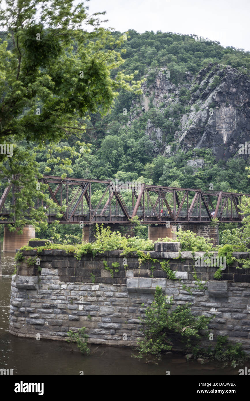 CSX Railway Bridge Potomac River Harpers Ferry West Virginia // HARPERS FERRY, West Virginia, Vereinigte Staaten — Eine historische Eisenbahnbrücke führt CSX-Gleise über den Potomac River von Harpers Ferry, West Virginia, nach Maryland. Die Brücke, ein integraler Bestandteil des Harpers Ferry National Historical Park, repräsentiert die anhaltende Bedeutung des Eisenbahnverkehrs an diesem landschaftlich reizvollen und historisch bedeutsamen Ort, an dem die Flüsse Potomac und Shenandoah zusammentreffen. Stockfoto