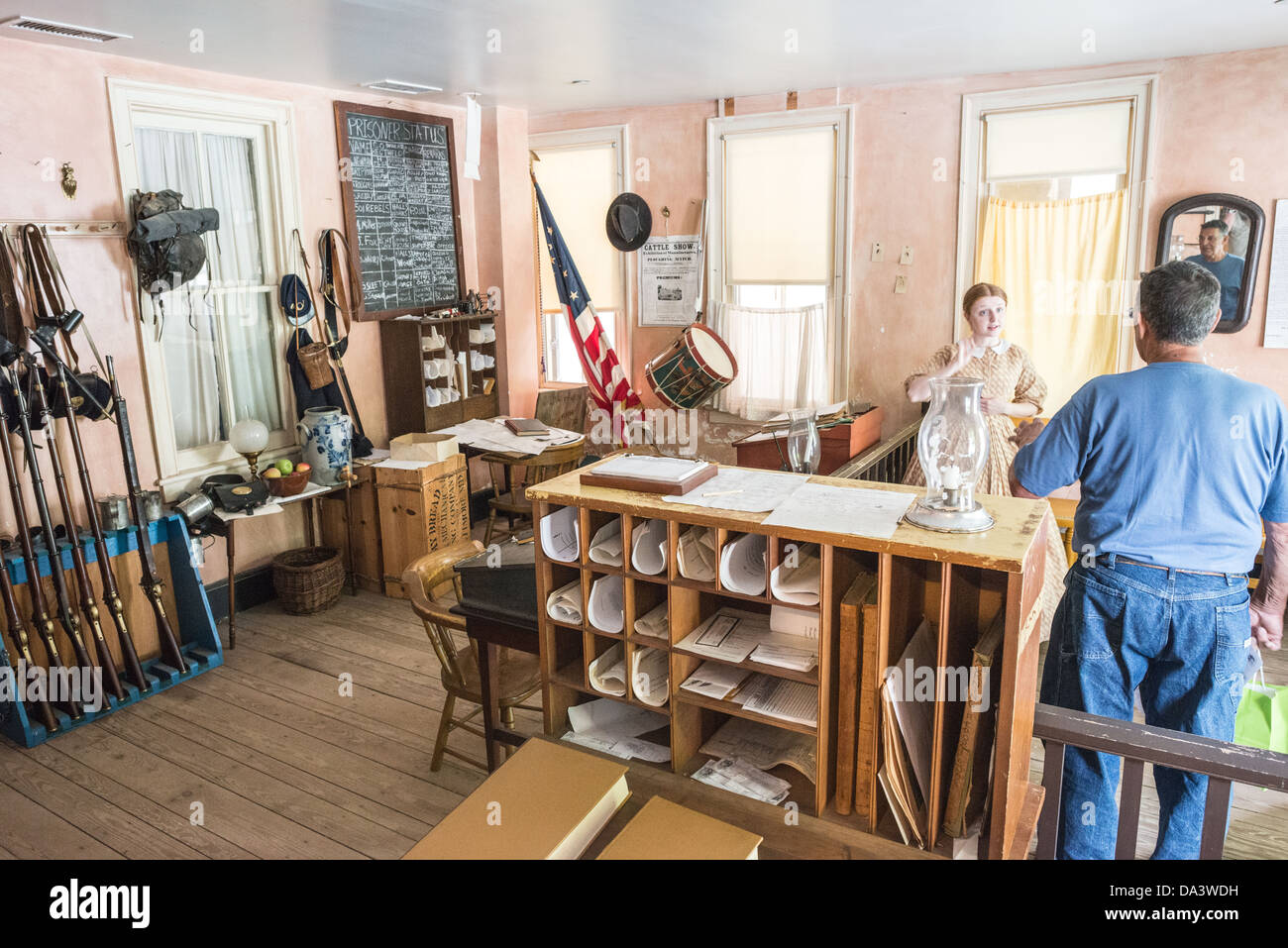 Harpers Ferry National Historical Park Living History West Virginia // HARPERS FERRY, West Virginia, Vereinigte Staaten — Ein kostümierter Dolmetscher im Harpers Ferry National Historical Park erklärt einem Besucher die Geschichte der Polizeistation aus dem 19. Jahrhundert. Diese lebendige Vorführung bietet Besuchern Einblicke in die Strafverfolgungspraktiken und die lokale Regierungsführung während der Vorkriegszeit und des Bürgerkriegs in dieser historisch bedeutsamen Stadt. Stockfoto