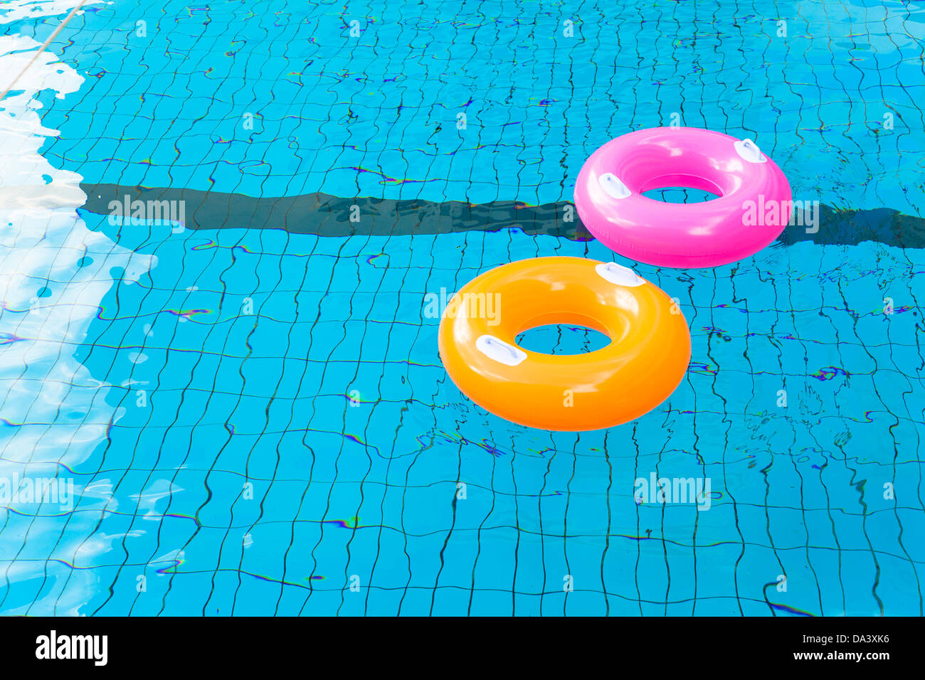 bunte Schwimmbad Ringe auf dem Wasser Stockfoto