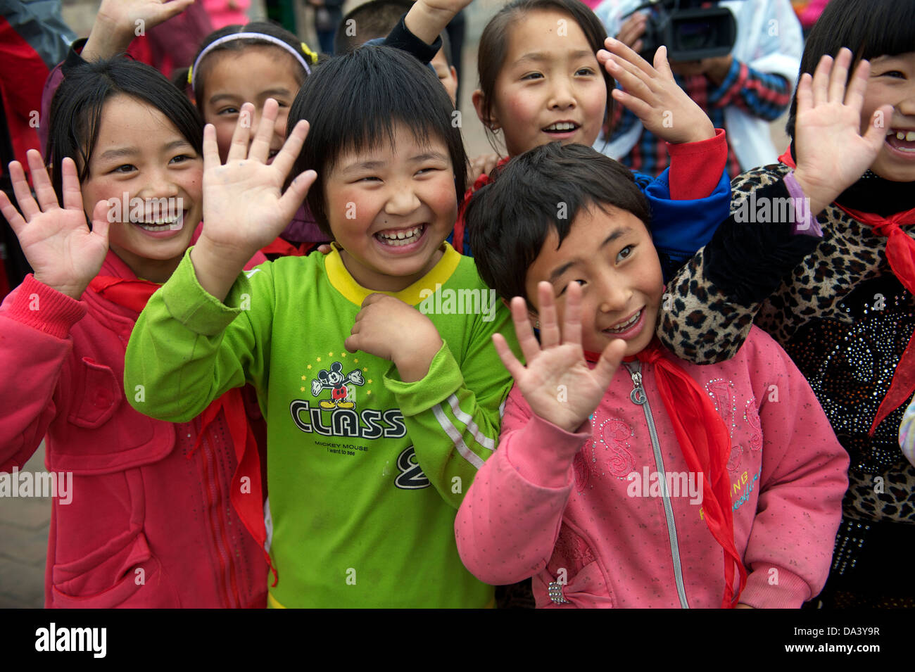 Studentinnen Welle ihre Hände für die Besucher in einer Grundschule in Haiyuan, Ningxia, China. 21. Mai 2013 Stockfoto