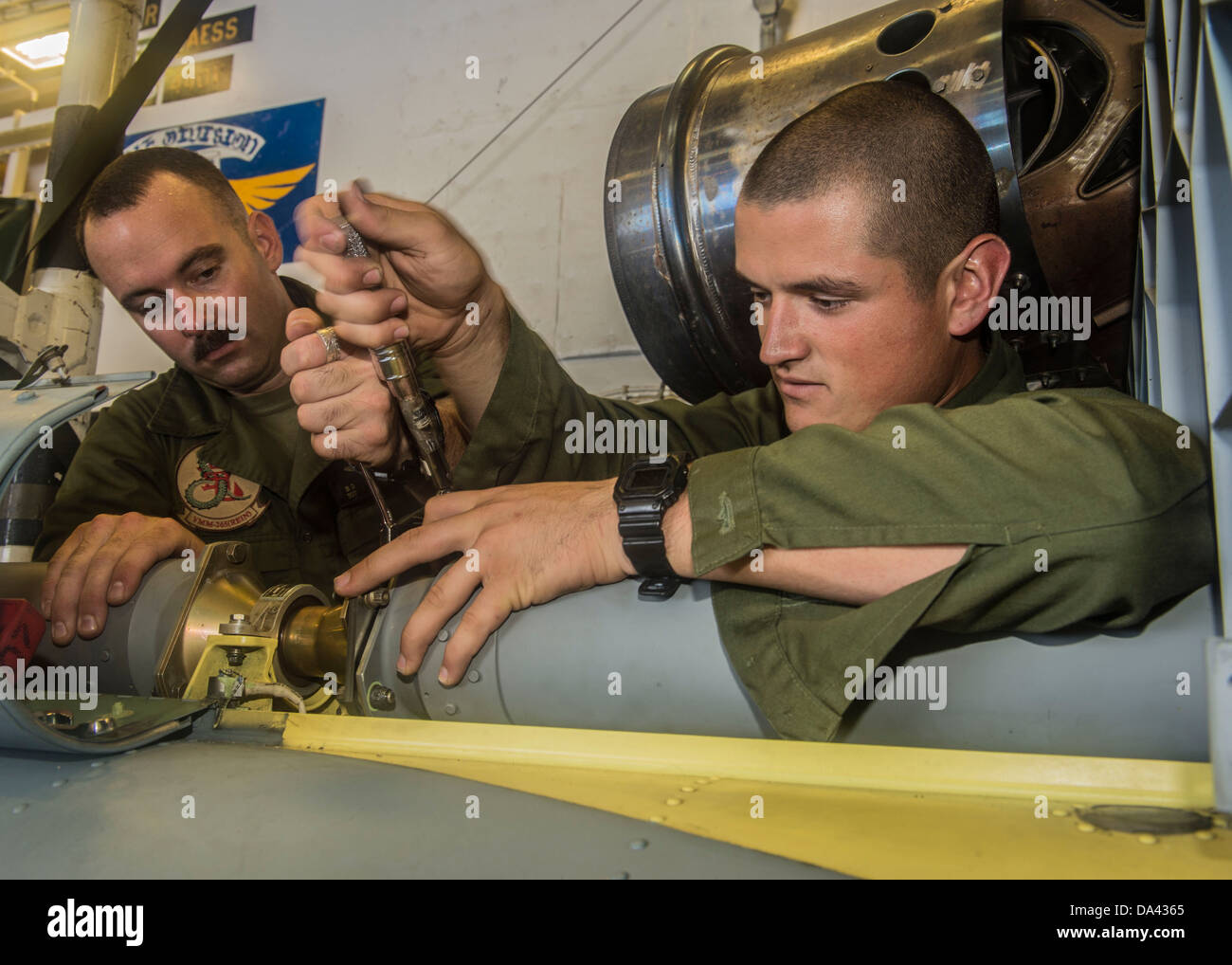 Sgt. Brian Richardson und CPL. Christopher Hernandez, zugeordnet zu den Drachen der Marine Medium Tiltrotor Squadron (VMM) 265, Wartungsarbeiten an einem UH-1Y Huey Hubschrauber im Hangar Bucht an Bord die vorwärts bereitgestellt amphibischer Angriff Schiff USS Bonhomme Stockfoto