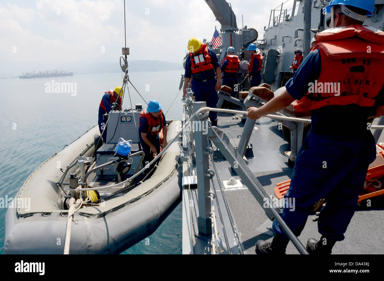 Matrosen hissen während flott Bereitschaft Zusammenarbeit und Ausbildung (CARAT) Philippinen 2013 ein kleines Boot an Bord der geführte Flugkörper-Zerstörer USS Fitzgerald (DDG-62). Karat ist eine Reihe von bilateralen militärischen Übungen zwischen der US-Marine und der Armee Stockfoto