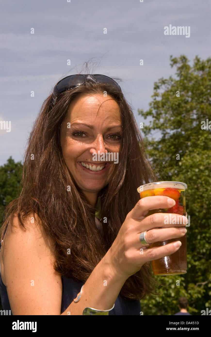 Junge Frau mit pimms genießen Sommer Fete, Blatt, Hampshire, UK. Stockfoto