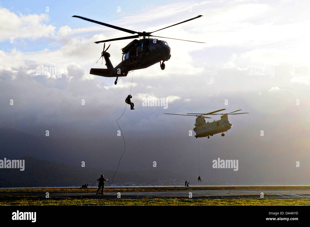 US Navy SEAL team Mitglieder Abseilen vom speziellen Streife Einfügung und Extraktion Seil befestigt ein UH-60 Black Hawk-Hubschrauber und ein CH-47F Chinook-Hubschrauber in HELOCAST Ausbildung bei Marine Corps Air Station Kaneohe Bay 19. Juni 2013 in Hawaii. Stockfoto