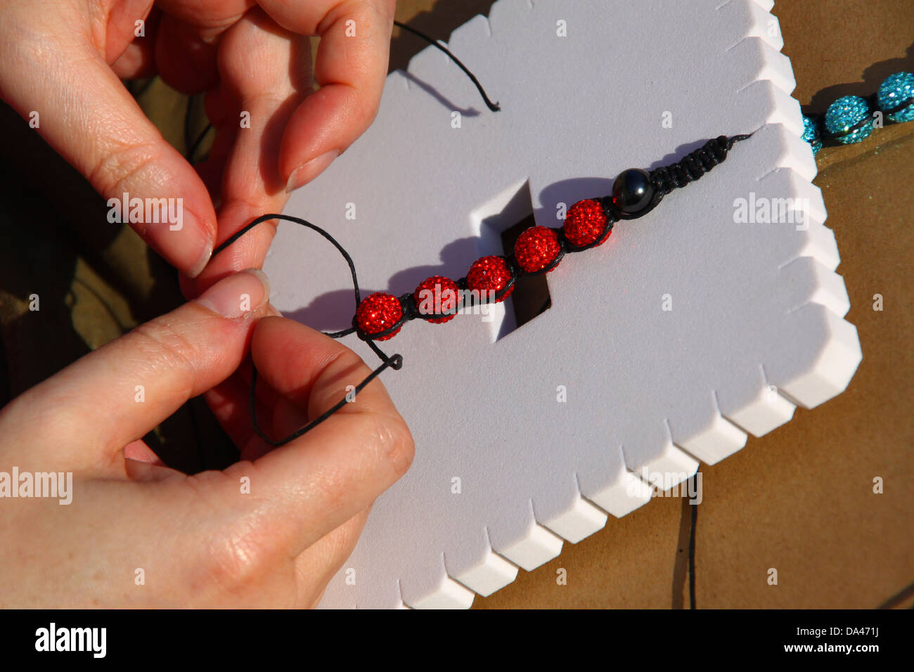 Herstellung von Shambala Stil Armbänder auf pad Stockfoto