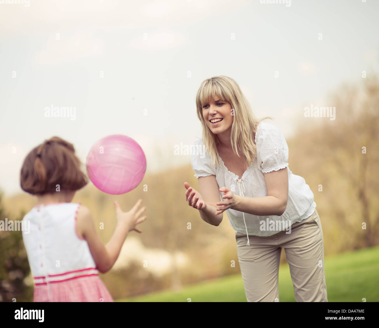 Familie wirft Ball zueinander im park Stockfoto