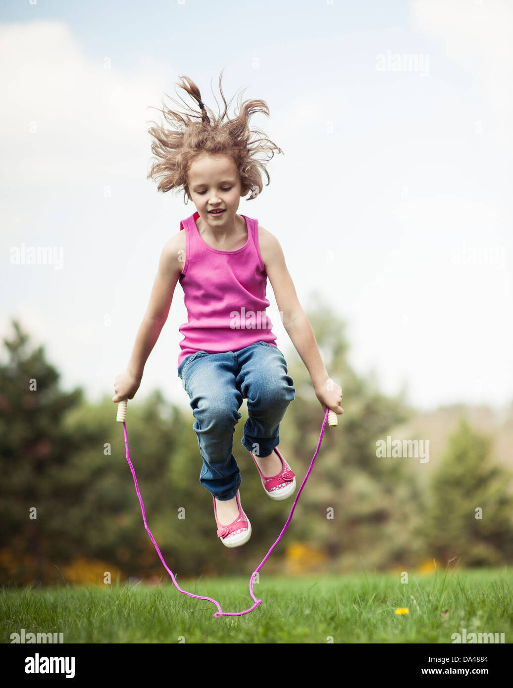 Junges Mädchen im Park überspringen Stockfoto