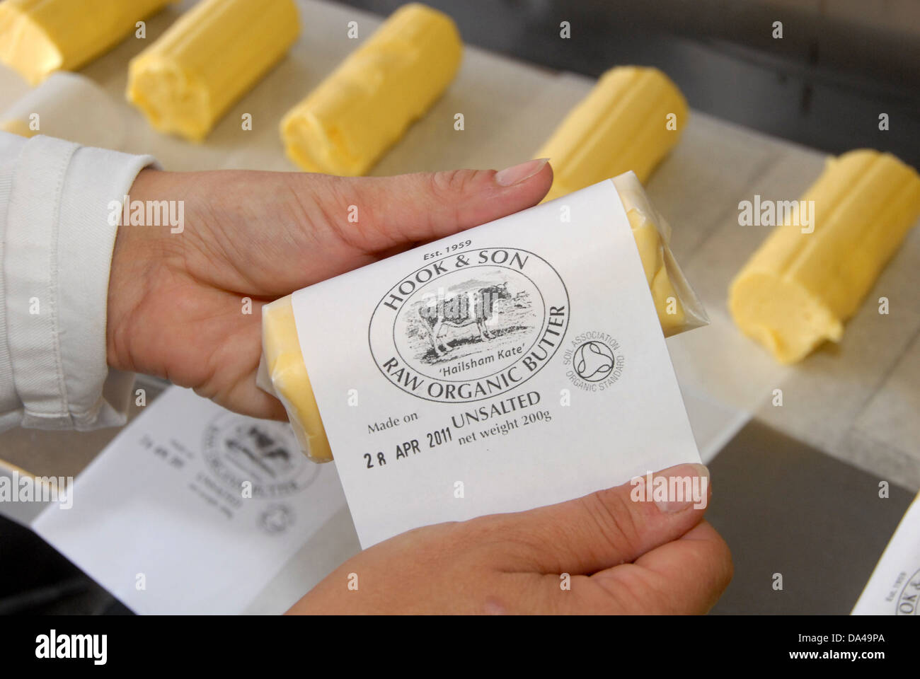 Arbeiter, die Kennzeichnung organisch gebildet Butter aus Rohmilch auf Bio Molkerei Haken und Sohn Longleys Farm in der Nähe Stockfoto
