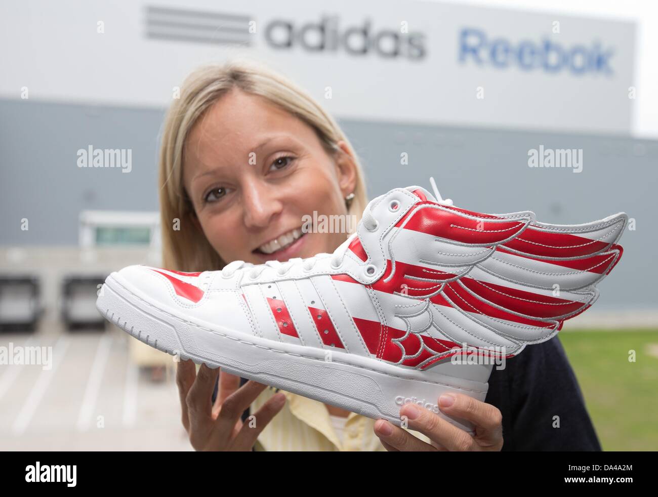 Adidas Mitarbeiter Carolin Jeibmann hält einen Schuh außerhalb das  Distribution Center in Rieste, Deutschland, 3. Juli 2013. Mit einem  Investitionsvolumen von mehr als 100 Millionen Euro hat der Welt größte  Adidas Group-Logistikzentrum