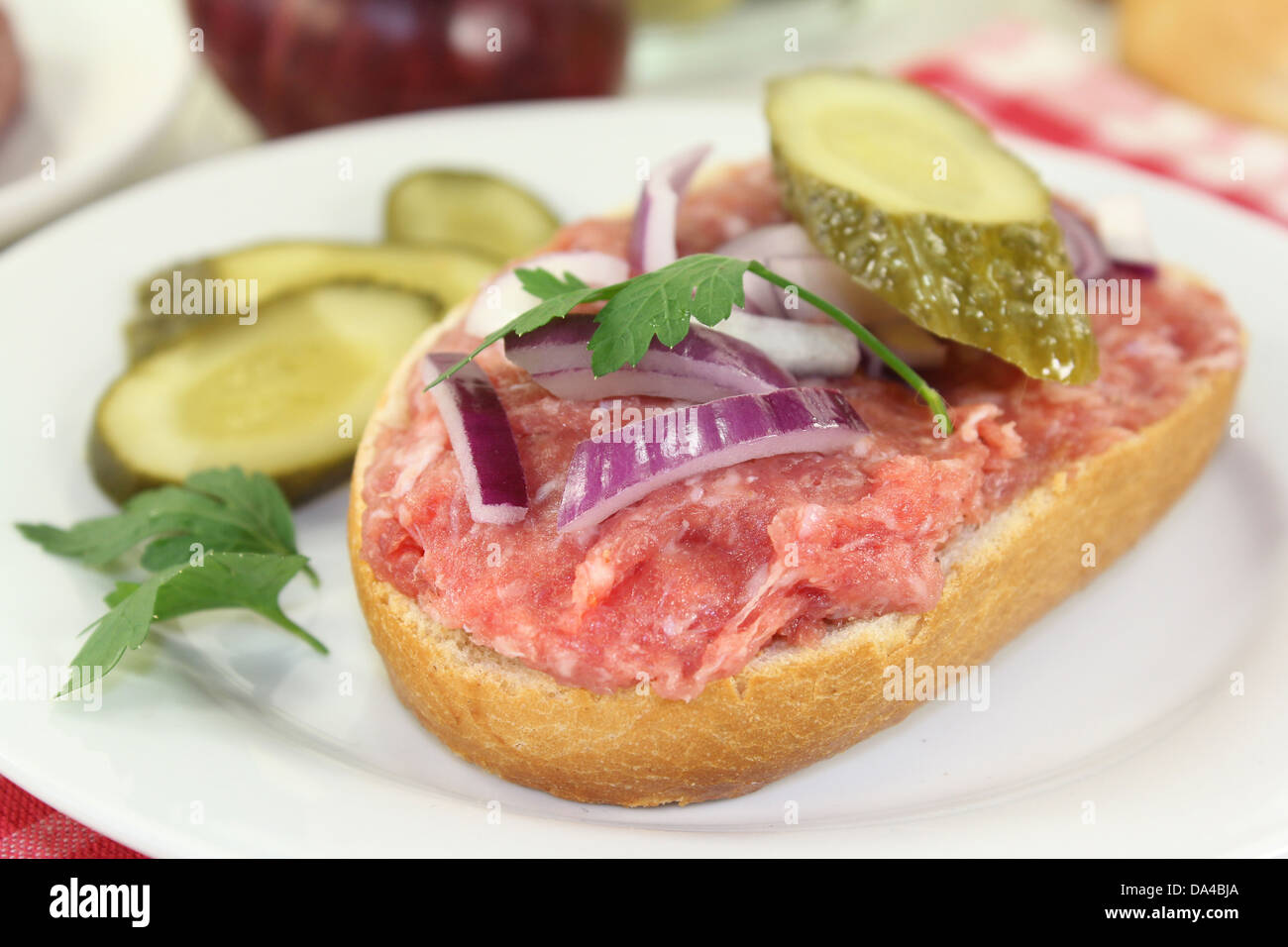 ein Boden Schweinefleisch Brötchen mit Zwiebeln und Gurken Stockfoto