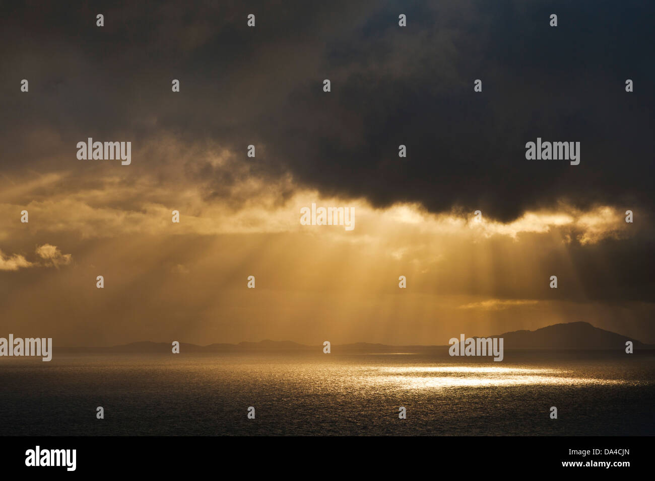 Abendlicht, das durch dunkle, stürmische Wolken auf das Meer scheint Schottland GB GB Europa Stockfoto