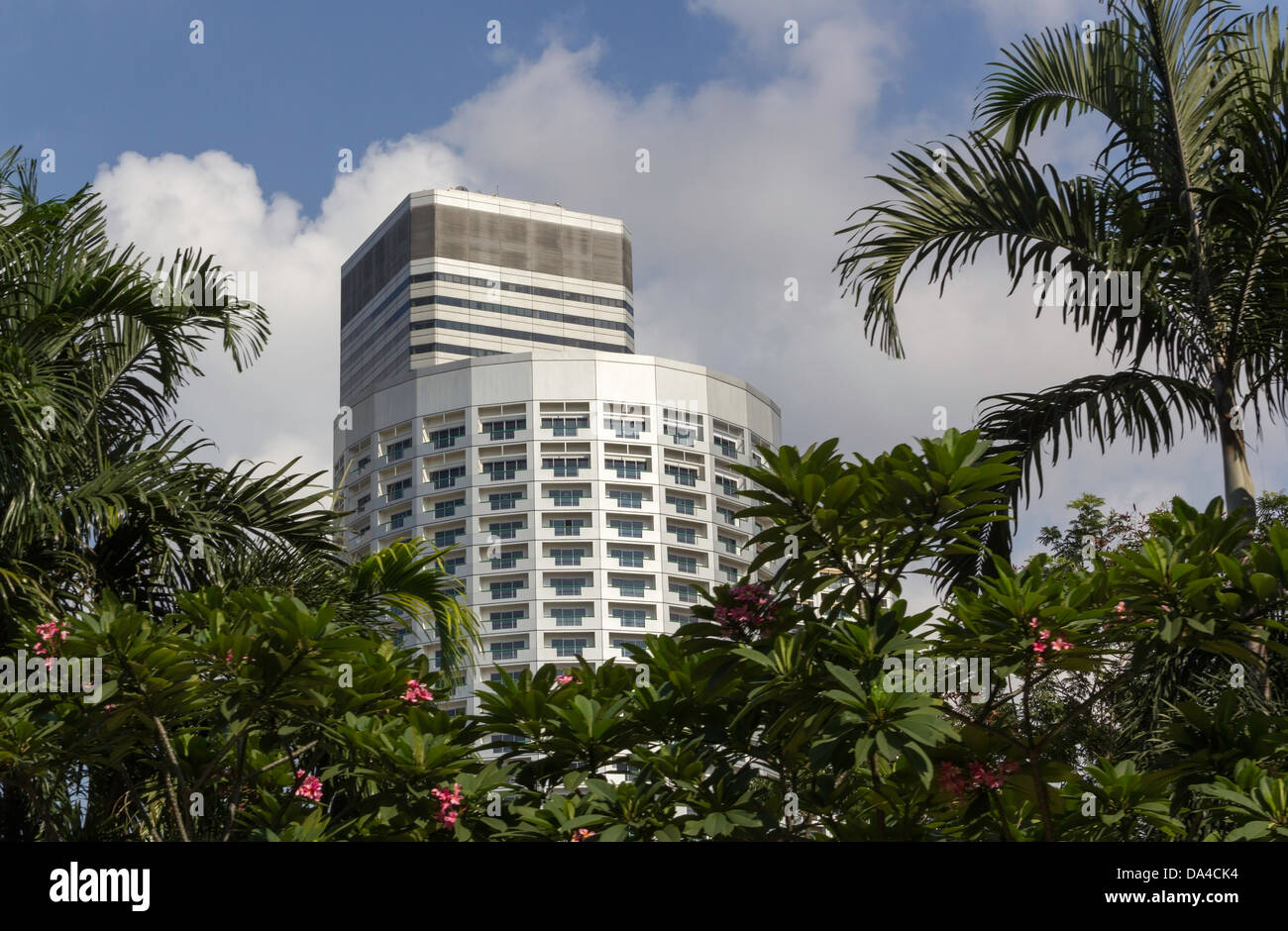 Ein hoch steigen Wohngebäude in Singapur hinter Bäumen und weiße Wolken bilden über das Gebäude, die einen Teil des Himmels Stockfoto