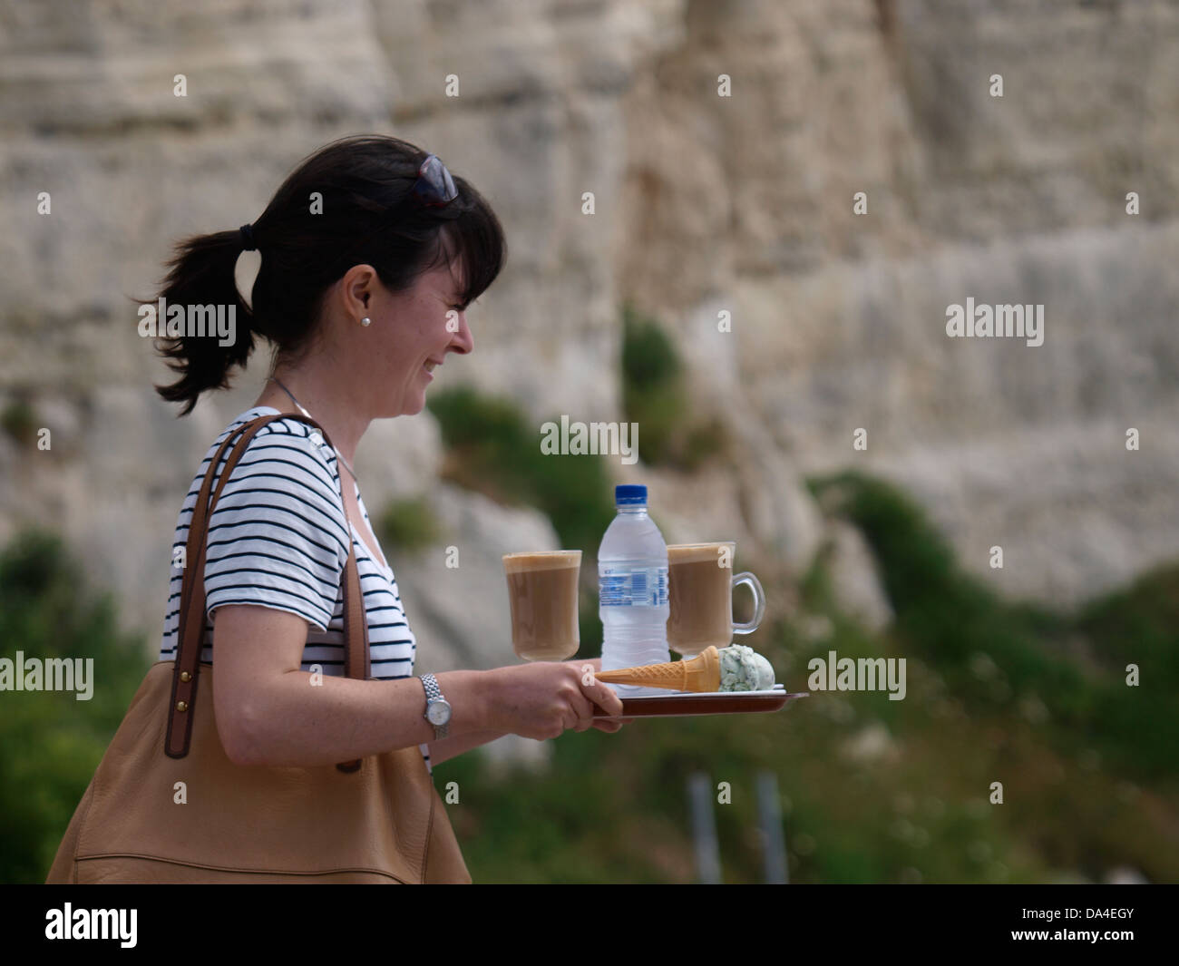 Frau mit einem Tablett mit Kaffee und ein Eis am Strand, Bier, Devon, UK 2013 Stockfoto