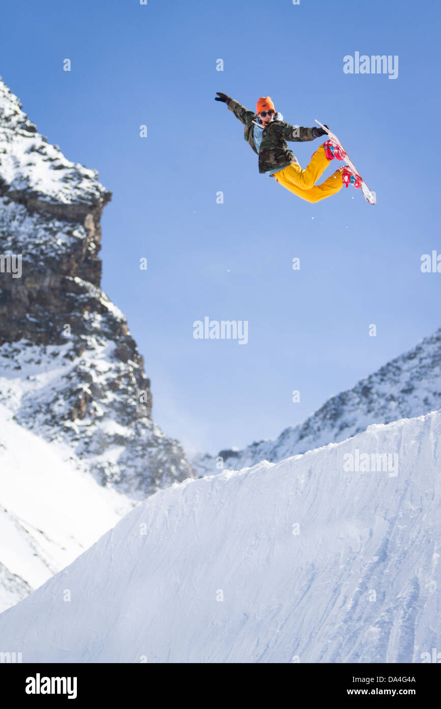 SAAS-FEE, WALLIS, SCHWEIZ. Ein Snowboarder ist einen Backside Air Trick an einer Ecke in einem Freestyle Snowpark ausführen. Stockfoto