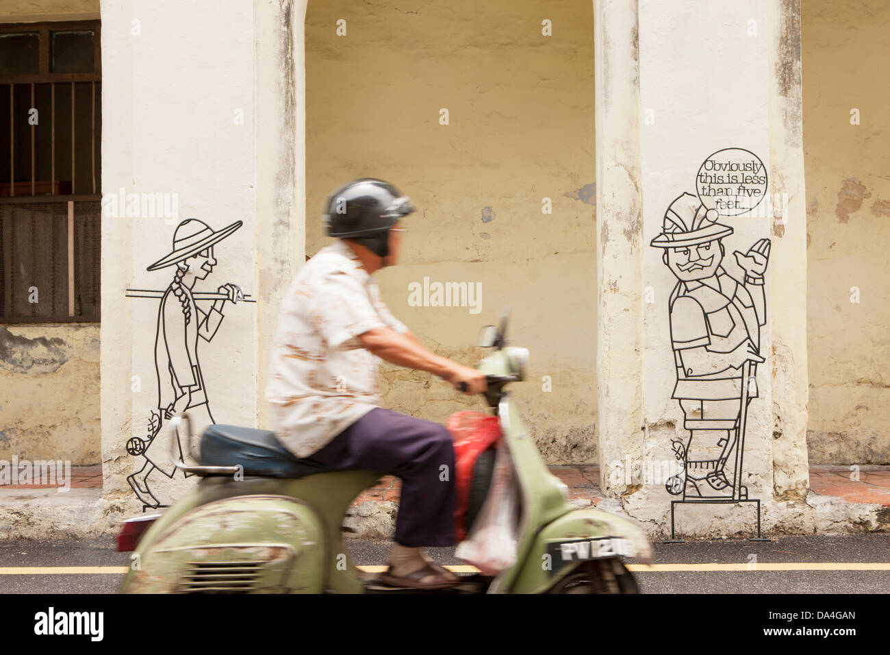 Mann reitet vorbei an street-Art, Georgetown, Penang, Malaysia Stockfoto