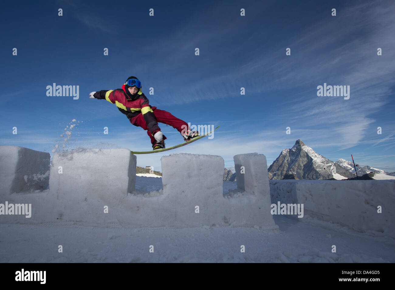 ZERMATT. Eine männliche Snowboarder Reiten einer Burgmauer aus Schnee mit einem Tailpress Trick gemacht. Im Hintergrund das Matterhorn-Berg. Stockfoto