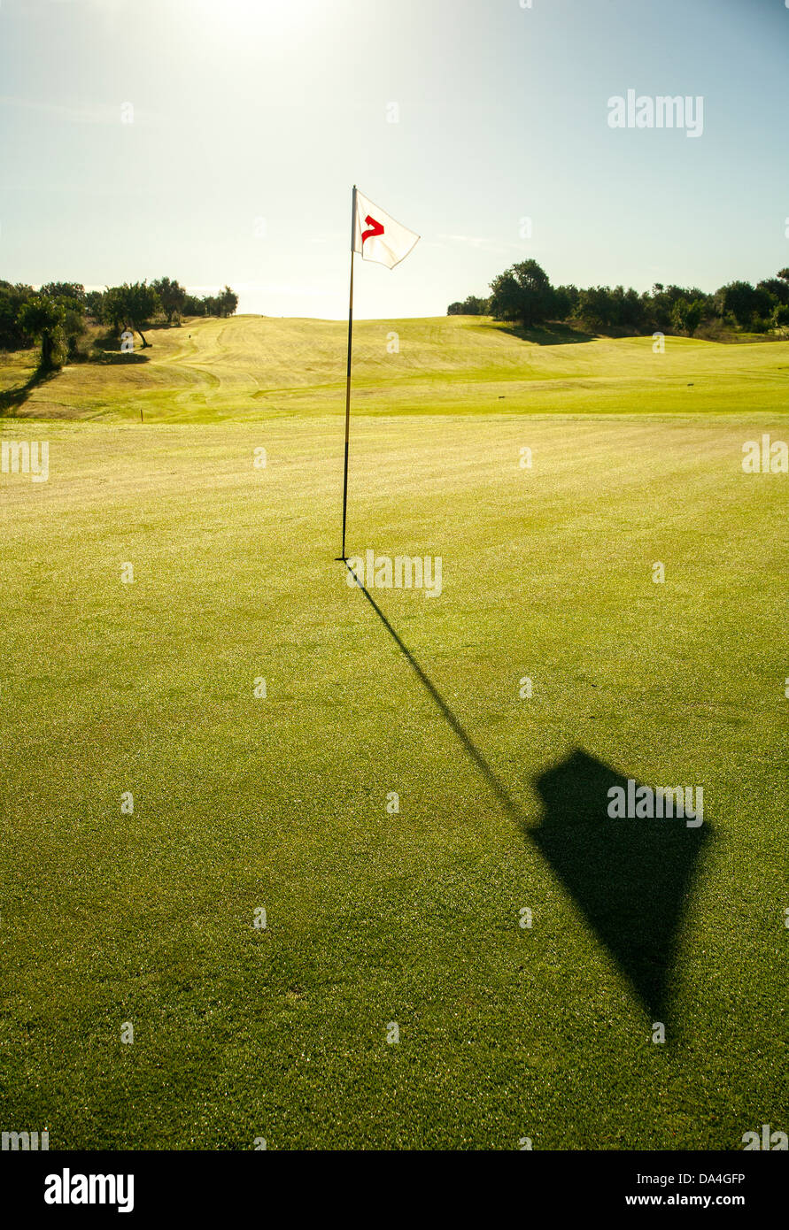 Golfflagge in hellem Grün Grün mit Blau des Meeres im Hintergrund. Stockfoto