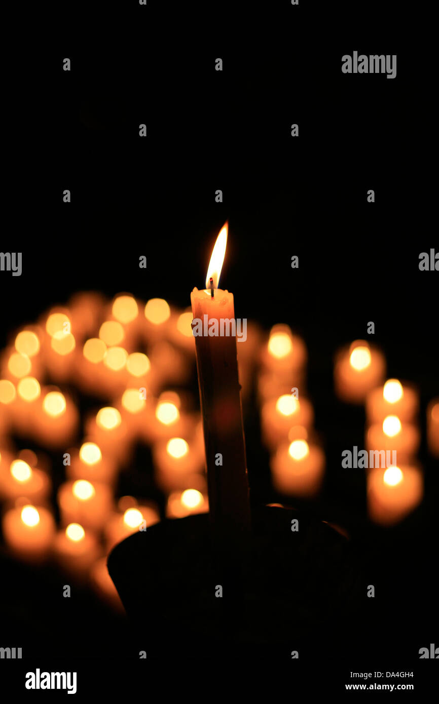 Gebet, Votiv oder Masse Kerzen gegen einen schwarzen Hintergrund. Stockfoto