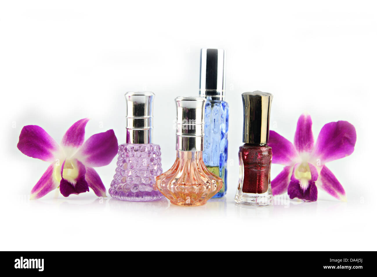 Die lila Orchidee und Parfüm-Flaschen auf dem weißen Hintergrund. Stockfoto