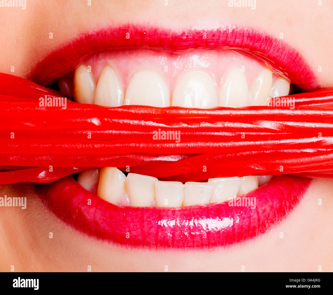 Eine Nahaufnahme von einer Frau Mund essen viel rote Lakritze Spitze Süßigkeiten Stockfoto