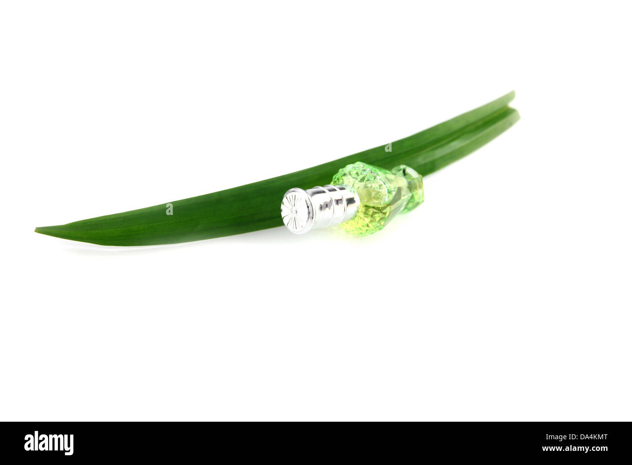 Grüne Flasche Parfüm und Pandanus auf weißem Hintergrund. Stockfoto