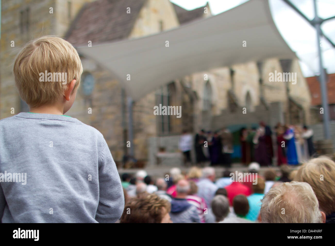 Ein kleiner Junge auf seinen Vater Schultern beobachtet, wie der Rattenfänger-Märchen erzählt von den Menschen in Hameln/Hameln Stockfoto