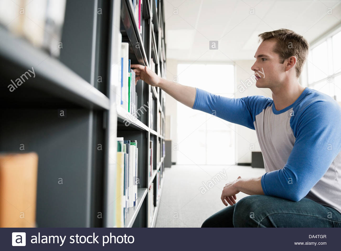 Männlichen Studenten, die Auswahl der Bücher in der Universitätsbibliothek Stockfoto