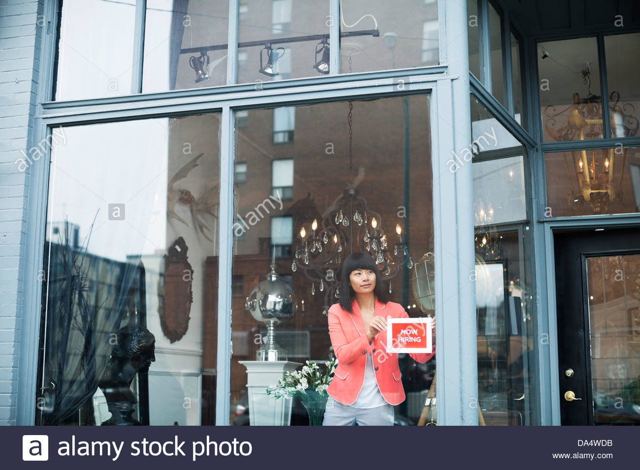 Weibliche Unternehmer Hilfe anzeigen wollte, dass Zeichen in Möbel Fenster speichern Stockfoto