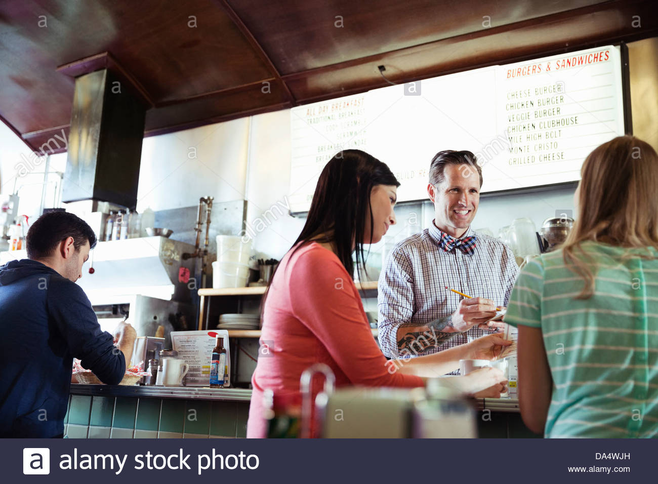 Diner-Besitzer, die Kunden Bestellungen am Schalter Stockfoto