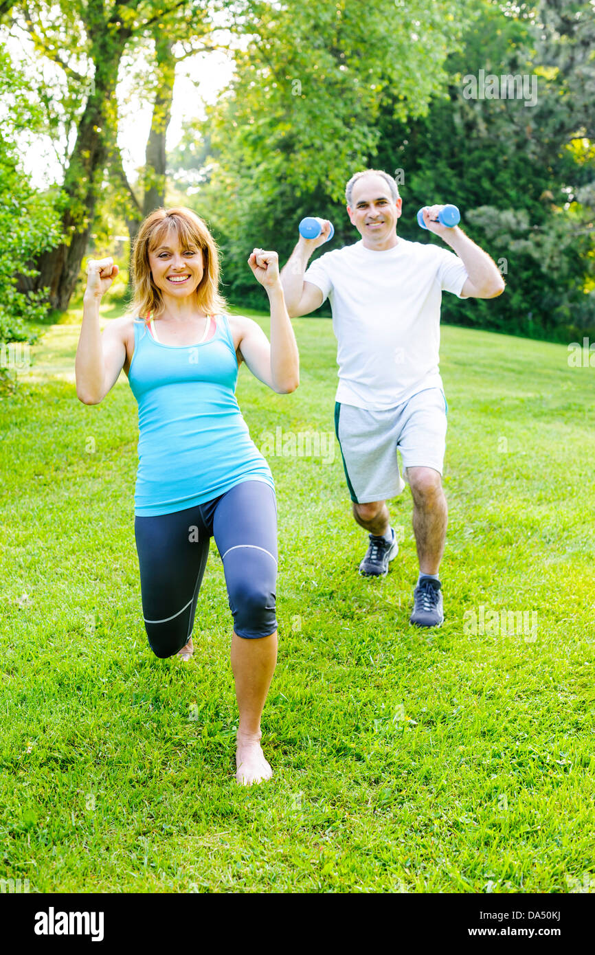 Frauen Fitness-Instruktor Training mit Mann mittleren Alters im grünen park Stockfoto