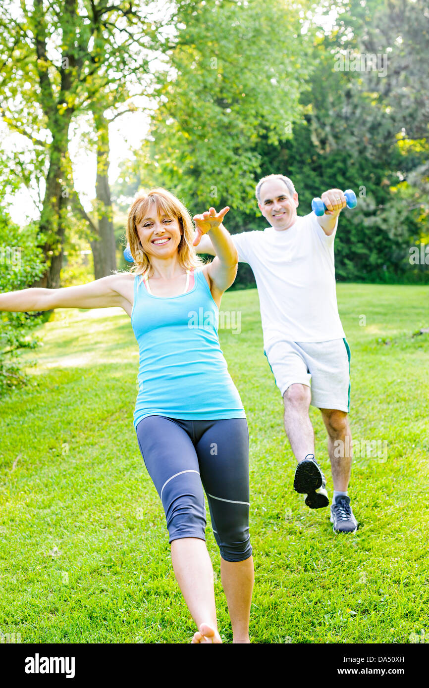 Frauen Fitness-Instruktor Training mit mittleren Alter Mann draußen im grünen park Stockfoto