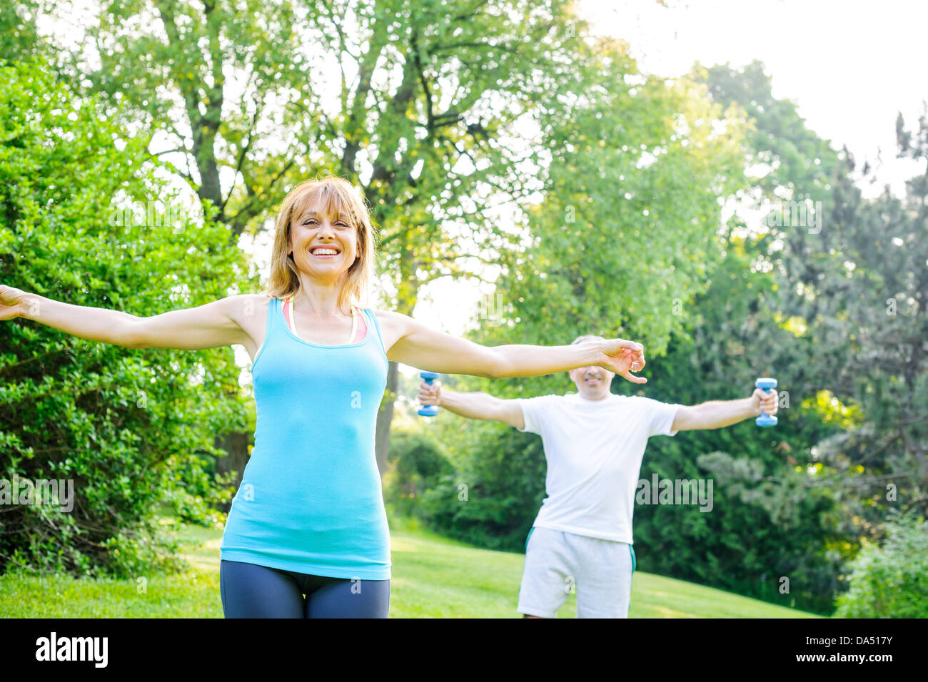 Weiblichen Fitness-Instruktor Training mit mittleren Alter Mann im Freien im Sommerpark Stockfoto