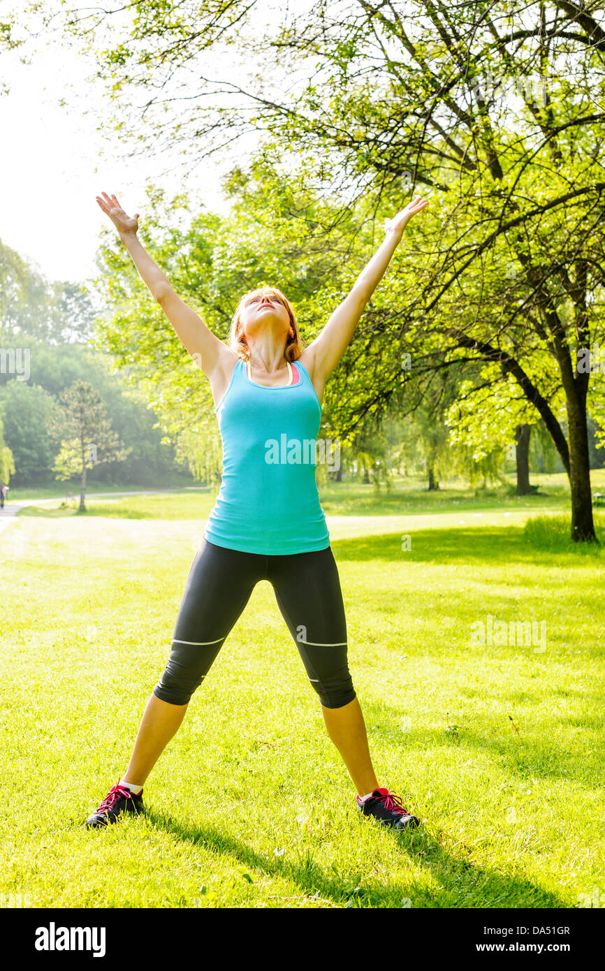 Frauen Fitness-Instruktor stretching am grünen Park am Morgen Stockfoto