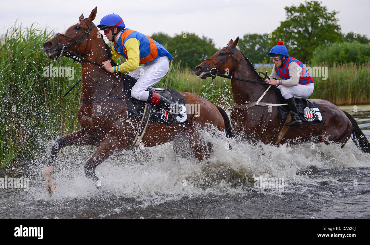 Hamburg, Deutschland. 3. Juli 2013. Jockey Oliver Schnakenberg (L) auf Rebel Tänzerin kreuzt eine Wasser-Hürde im See Jagd Rennen (Seejagdrennen) im Pferdesport Galopp Derby Meeting auf der Rennbahn Hamburg Horn in Hamburg, Deutschland, 3. Juli 2013. Foto: AXEL HEIMKEN/Dpa/Alamy Live News Stockfoto