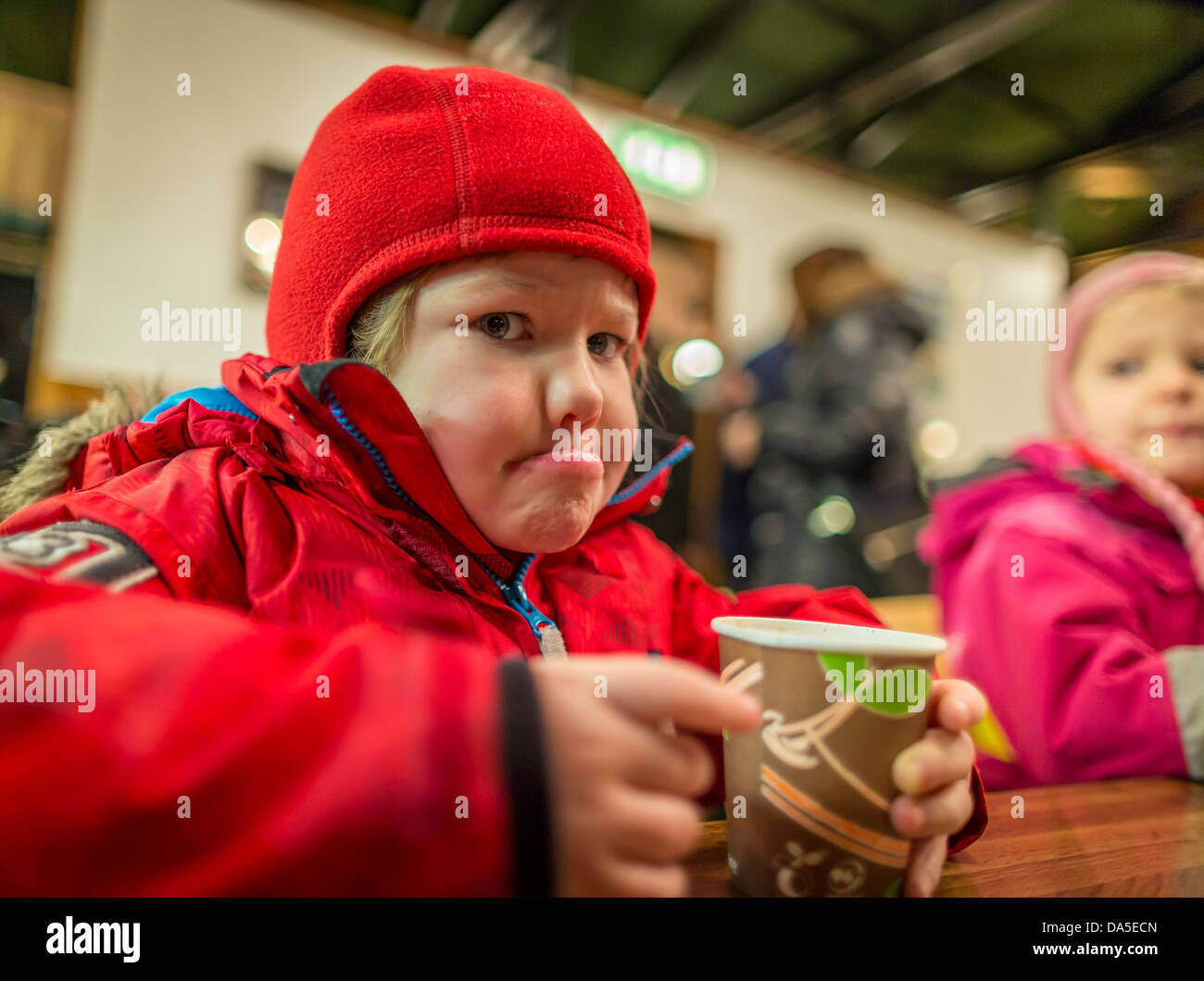 Junge Mädchen genießen heißen Kakao in einem örtlichen Café in Reykjavik, Weihnachtszeit, Island Stockfoto