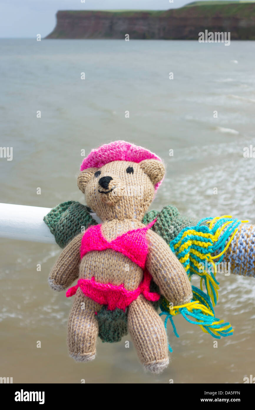 Yarn Bombing dekorieren öffentlichen Platz mit gestrickten Objekte hier ein Teddybär in einem Bikini Badeanzug auf Saltburn Pier Stockfoto