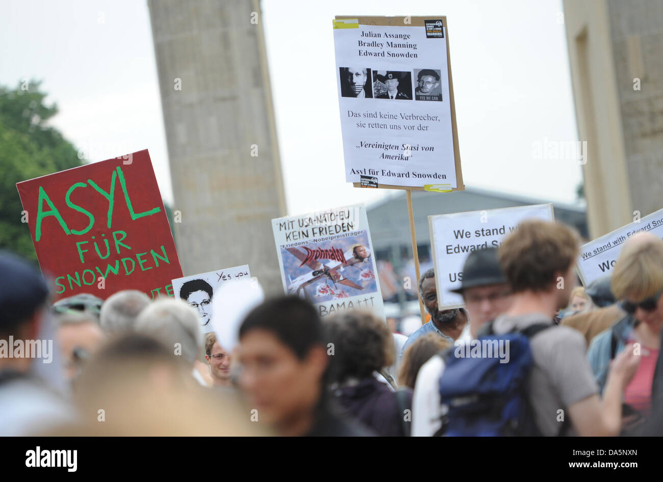 Demonstranten stehen vor dem Brandenburger Tor mit Plakaten um ihre Unterstützung für ehemalige technische Dienstleister von der zentralen Intelligenz Agentur Edward Snowden in Berlin, Deutschland, 4. Juli 2013 zeigen. Snowden zugespielt Auskunft über Daten-Spionage-Programme von den USA und Großbritannien im Juni 2013. Foto: Ole Spata Stockfoto